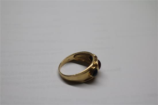 A yellow metal, cabochon ruby and sapphire three stone dress ring, size R.